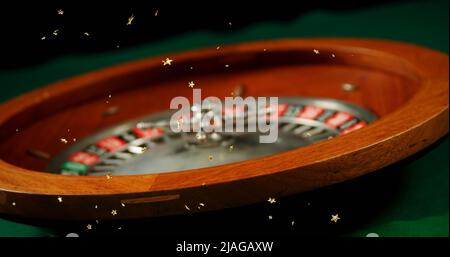 Immagine composita di più icone stella d'oro che cadono contro il primo piano della roulette russa che gira. casino e concetto di gioco d'azzardo Foto Stock