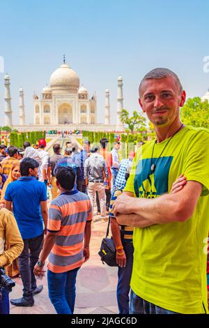 Il viaggiatore e il turista pone di fronte al famoso Taj Mahal in Agra India Mogul marmo mausoleo e panorama del famoso 17th secolo simmetrico g Foto Stock