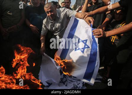 Gaza, Palestina. 29th maggio 2022. I palestinesi bruciano le rappresentazioni delle bandiere israeliane durante la protesta per le tensioni nella Moschea al-Aqsa di Gerusalemme a Khan Younis, la striscia meridionale di Gaza. Credit: SOPA Images Limited/Alamy Live News Foto Stock