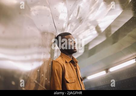 Felice giovane donna con occhi chiusi in piedi in galleria Foto Stock