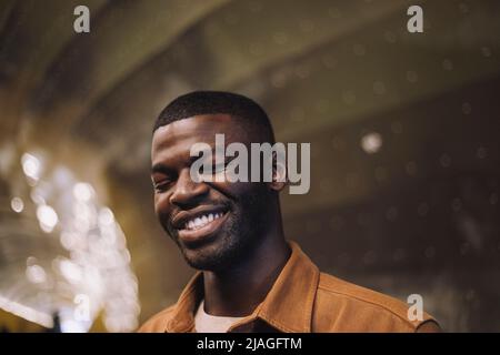 Sorridente giovane con gli occhi chiusi nel tunnel Foto Stock