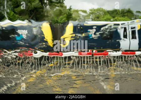 Un treno sud-occidentale che attraversa il livello Vine Road di Network Rail attraversando le barriere in caso di pioggia battente, Barnes, Londra sud-occidentale, Inghilterra, Regno Unito Foto Stock