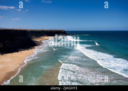 Vista lungo parte della spiaggia di El Cotillo sulla costa occidentale di Fuerteventura, Isole Canarie, Spagna. La spiaggia di El Cotillo è rinomata per il surf Foto Stock