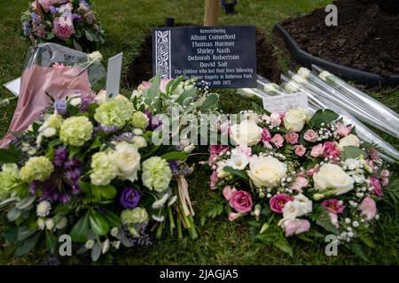 Tributi di fiori prima di una piantagione di alberi e cerimonia di inaugurazione della placca per il 50th anniversario della tragedia di Battersea Park Big Dipper, a Battersea Park, nel sud-ovest di Londra. Cinque bambini sono stati uccisi e altri 13 feriti il 30 1972 maggio, quando le montagne russe Big Dipper sono crollate. Data foto: Lunedì 30 maggio 2022. Foto Stock