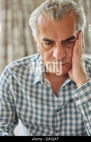 Testa e spalle Tiro di un uomo anziano preoccupato a casa Foto Stock