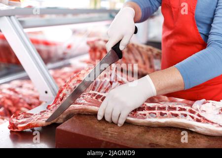 Primo piano di macelleria tagliando porks di qualità Foto Stock