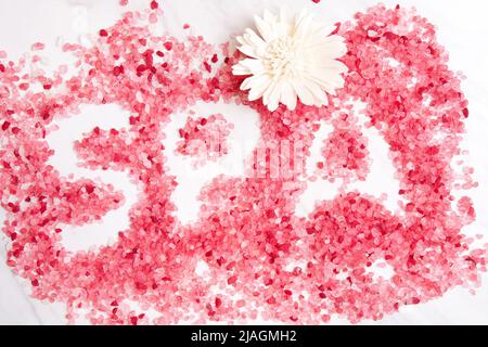 La parola SPA è disposta da sali da bagno su un tavolo di marmo. Terapia di bellezza e assistenza sanitaria Foto Stock