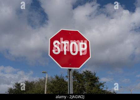 Segnale di stop con cielo blu e nuvole bianche sullo sfondo. Foto Stock