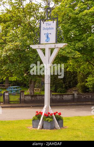 Cartello in legno sul verde del villaggio per il pub Dolphin, Thorpeness, Suffolk. REGNO UNITO Foto Stock