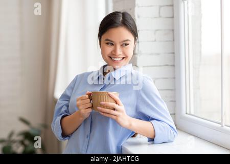Ritratto di bella donna asiatica felice bere caffè Foto Stock