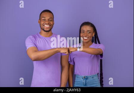 Ritratto di felice coppia nera festeggia vittoria battendo pugni Foto Stock