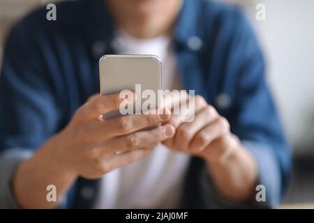 Tecnologie moderne. Primo piano Shot di un giovane uomo irriconoscibile con smartphone Foto Stock