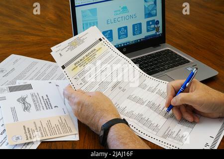 Lago Elsinore, CA, Stati Uniti d'America - Maggio 30,2022: Primo piano di uomo che riempie fuori 2022 California elezioni primarie. Foto Stock