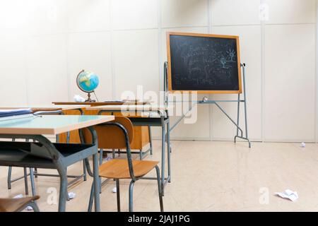scrivanie e lavagna in aula a scuola Foto Stock