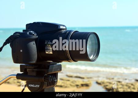 Sinai, Egitto, 23 2018 agosto: Una macchina fotografica digitale Nikon su un treppiede che riprende e registra una scena naturale su una spiaggia del Sinai del Sud di fronte al rosso s Foto Stock