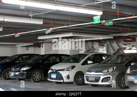 Cairo, Egitto, 14 2022 aprile: Auto parcheggiate all'interno di un parcheggio auto a più piani edificio, fuoco selettivo di auto moderne all'interno di un parcheggio chiuso gara Foto Stock