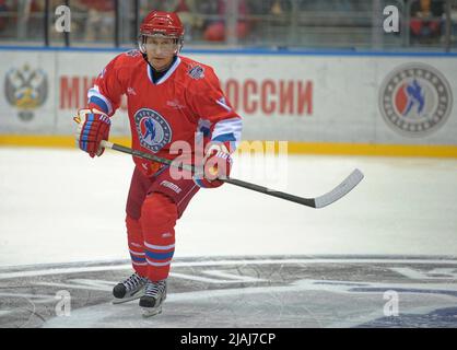 Il presidente russo Vladimir Putin scivola giù per il ghiaccio durante una partita della Lega di hockey del Festival di Notte di tutta la Russia tra giocatori di hockey dilettanti e star di hockey russe sabato 10 maggio 2014 a Sochi, Krasnodar Krai, Russia. Putin, 62 anni, ha preso una pausa dai colloqui con l’Occidente sulla recente annessione russa della Crimea per giocare insieme alle leggende dell’ex hockey sovietico nella partita di gala casuale. (Foto di Apex MediaWire di Alexey Druzhinin/RIA Novosti) Foto Stock