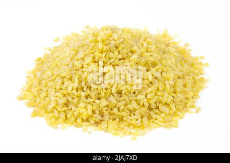 Mucchio di grano grezzo secco di bulgur su sfondo bianco. Mucchio di bulgur asciutto primo piano. Foto Stock