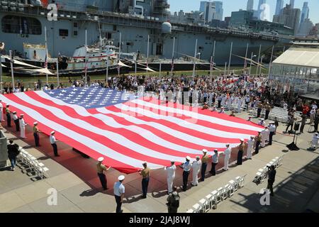 New York, Stati Uniti. 30th maggio 2022. La gente sfora una bandiera americana durante un evento che segna il Memorial Day al Intrepid Sea, Air and Space Museum di New York, Stati Uniti, il 30 maggio 2022. I newyorkesi hanno celebrato il Memorial Day il lunedì con sfilate e altre attività, che somigliavano alle celebrazioni nel tempo prima della pandemia del COVID. Credit: Liu Yanan/Xinhua/Alamy Live News Foto Stock