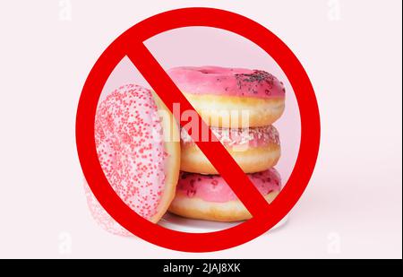Ciambelle dolci e cartello di divieto su sfondo chiaro Foto Stock