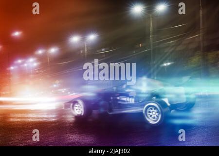 Auto da corsa veloce sulla strada notturna della città Foto Stock