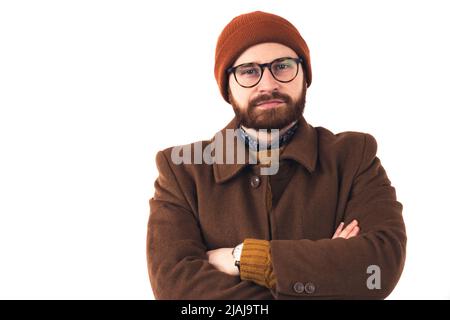 Ritratto di un'azienda di moda ported il CEO maschio in autunno marrone outwear con le braccia incrociate guardando direttamente alla macchina fotografica su sfondo bianco. Foto di alta qualità Foto Stock