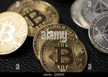 Monete Bitcoin ed etereo su sfondo nero. Valuta digitale sulla superficie in pelle. Acquistare beni di lusso con bitcoin ed etereo Foto Stock