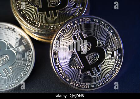 Monete in Bitcoin d'oro e d'argento su sfondo scuro Foto Stock