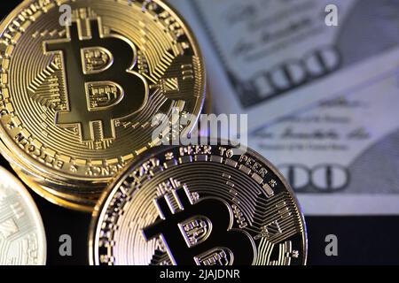 Monete in Bitcoin con banconote in dollari USA in background Foto Stock