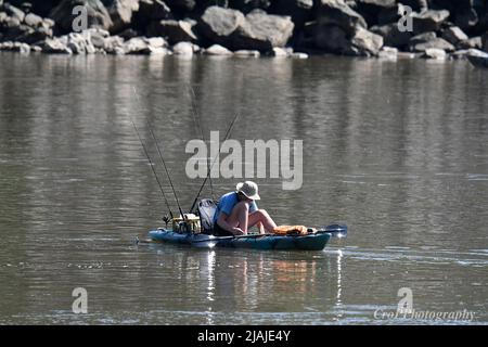 Giovane uomo sulla piccola barca pesca nel fiume Susquehanna vicino Conowingo Dam Foto Stock