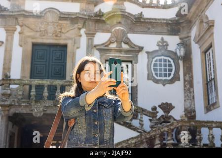 Donna che fotografa con il suo smartphone al Mateus Palace di Vila Real Foto Stock