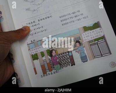 YICHANG, CINA - 31 MAGGIO 2022 - Un cittadino mostra le illustrazioni del secondo volume del libro di matematica di quarto grado per le scuole primarie pubblicato Foto Stock