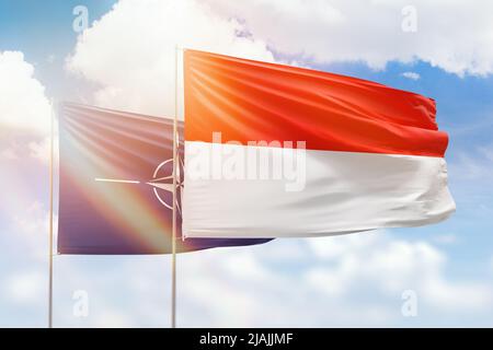 Cielo azzurro soleggiato e bandiere dell'indonesia e della nato Foto Stock