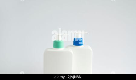 Due contenitori liquidi per gel, lozione, crema, shampoo, schiuma da bagno. Flacone in plastica cosmetica con pompa dispenser su sfondo bianco. Confezione cosmetica Foto Stock