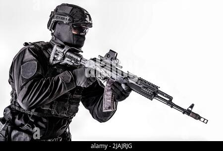 Ritratto dello studio della polizia speciale membro della squadra di reazione nero uniforme e casco, armato con fucile d'assalto. Foto Stock