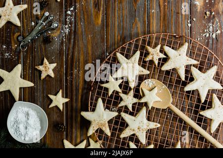 Biscotti allo zucchero di mandorla con glassa cosparsi di noce moscata e cannella. Tavolo da dessert per le feste con prodotti da forno e verdure invernali per Natale Foto Stock