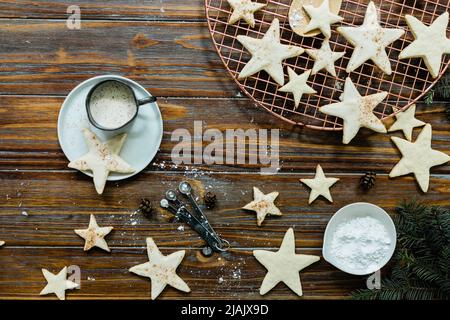 Biscotti allo zucchero di mandorla con glassa cosparsi di noce moscata e cannella. Tavolo da dessert per le feste con prodotti da forno e verdure invernali per Natale Foto Stock