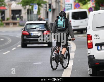 Dresda, Germania. 27th maggio 2022. Un ciclista passa davanti a un'auto parcheggiata sulla pista ciclabile nel quartiere Neustadt di Dresda. Credit: Robert Michael/dpa/Alamy Live News Foto Stock