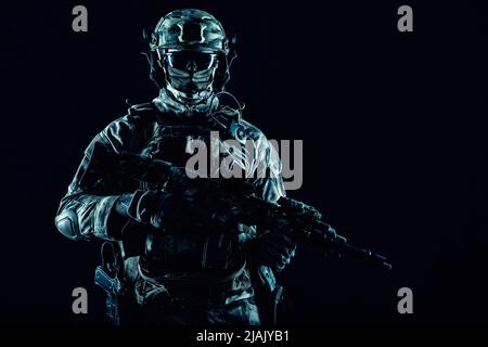 Operazioni speciali forza soldato indossare maschera, armato con mitragliatrice pistola, su sfondo nero. Foto Stock