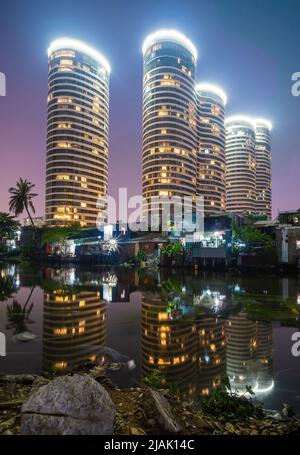 Una scena di contrasto tra nuovi edifici moderni e baraccopoli in paesi in via di sviluppo come il Vietnam. Un paesaggio rappresenta un riflesso tra ricco e poo Foto Stock