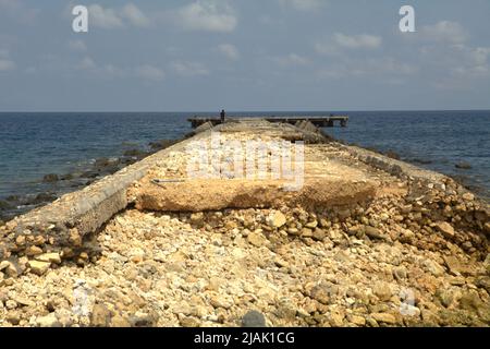 Un molo abbandonato di fronte all'Oceano Indiano, fotografato durante la stagione secca a Rua, Isola di Sumba, Nusa Tenggara Est, Indonesia. Foto Stock