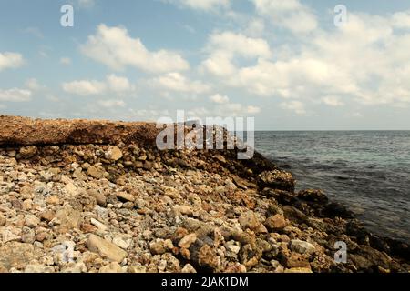 Un molo abbandonato di fronte all'Oceano Indiano, fotografato durante la stagione secca a Rua, Isola di Sumba, Nusa Tenggara Est, Indonesia. Foto Stock