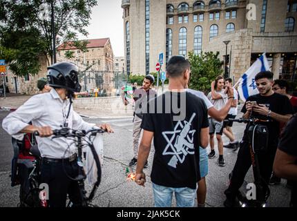 Tel Aviv, Israele. 29th maggio 2022. I giovani dell'ala destra israeliana bruciano una bandiera palestinese a Gerusalemme. Circa 70.000 nazionalisti ebrei marciarono attraverso e intorno alla Città Vecchia di Gerusalemme la domenica pomeriggio, segnando il 55th Gerusalemme Day, alcuni di loro cantarono slogan razzisti e si scontrarono anche con i palestinesi e la polizia. Credit: SOPA Images Limited/Alamy Live News Foto Stock