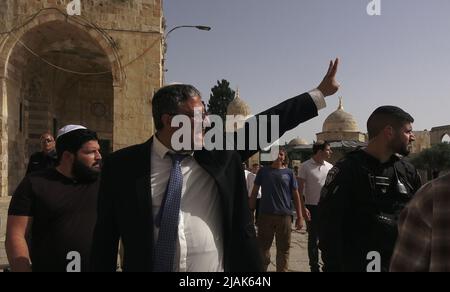 GERUSALEMME, ISRAELE - MAGGIO 29: Estrema destra, Itamar ben-Gvir, membro della Knesset, che sostiene l'espulsione di israeliani-arabi non sufficientemente fedeli ad Israele, trattiene il segno della vittoria e grida "il popolo di Israele è vivo" mentre visita con israeliani ultra-nazionalisti il monte del Tempio noto ai musulmani come Haram esh-Sharif (Santuario del Nobile) Durante la festa israeliana 'Jerusalem Day' davanti al nazionalista ebraico 'marcia bandiera' nella città vecchia il 29 maggio 2022 a Gerusalemme, Israele. La marcia della bandiera del giorno di Gerusalemme segna l'anniversario dell'unificazione della Città Vecchia e di Gerusalemme Est nel 1967. Foto Stock