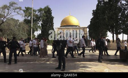 GERUSALEMME, ISRAELE - MAGGIO 29: I poliziotti israeliani scortano un gruppo di israeliani ultra-nazionalisti che visitano il Monte del Tempio conosciuto dai musulmani come Haram esh-Sharif (Santuario del Nobile) durante la festa israeliana 'Jerusalem Day' davanti al nazionalista ebraico 'flag march' nella città vecchia il 29 Maggio 2022 a Gerusalemme, Israele. La marcia della bandiera del giorno di Gerusalemme segna l'anniversario dell'unificazione della Città Vecchia e di Gerusalemme Est nel 1967. Foto Stock