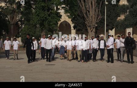 GERUSALEMME, ISRAELE - MAGGIO 29: I poliziotti israeliani scortano un gruppo di israeliani ultra-nazionalisti che visitano il Monte del Tempio conosciuto dai musulmani come Haram esh-Sharif (Santuario del Nobile) durante la festa israeliana 'Jerusalem Day' davanti al nazionalista ebraico 'flag march' nella città vecchia il 29 Maggio 2022 a Gerusalemme, Israele. La marcia della bandiera del giorno di Gerusalemme segna l'anniversario dell'unificazione della Città Vecchia e di Gerusalemme Est nel 1967. Foto Stock