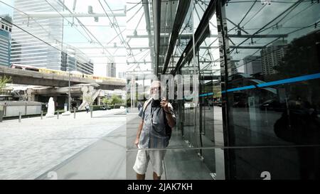 Turista zaino in spalla che prende foto di Selfie al cavalcavia della stazione di Chong Nonsi BTS al cavalcavia dello skywalk all'intersezione di Sathorn-Narathiwas in Bangkok Thailandia Foto Stock