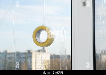 Sigillare le finestre con nastro adesivo durante la guerra in Ucraina per prevenire la formazione di molti frammenti durante l'ondata di esplosione Foto Stock