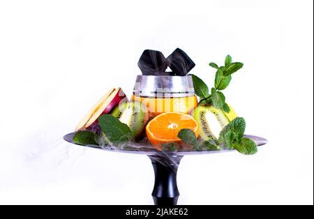 Ciotola di frutta per la zoccoli con arancia, mela, lime, mandarino, menta con kaluda, con carbone di cocco e fumo su sfondo bianco. Isolato Foto Stock