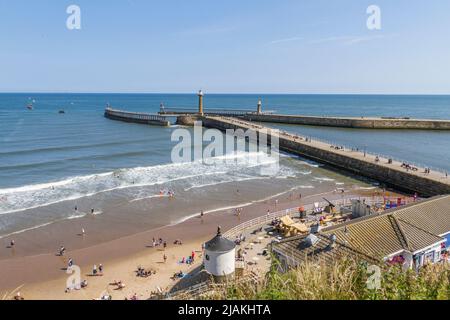 L'ingresso al Whitby Harbour include il Whitby Harbour West Lighthouse e West Pier, Whitby, North Yorkshire, Inghilterra. Foto Stock